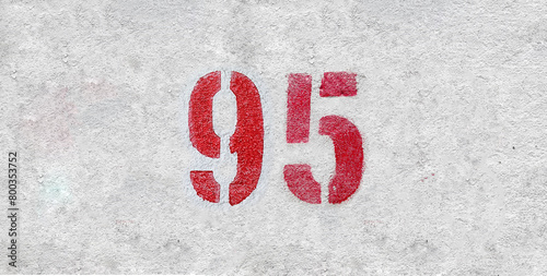 Red Number 95 on the white wall. Spray paint.