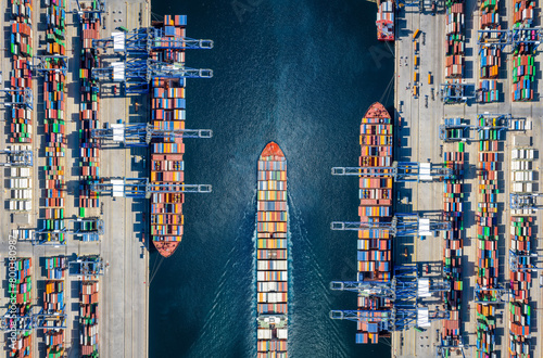 Obraz na płótnie Aerial top down view of a large container cargo ship terminal with loading activity and vessel traffic w salonie