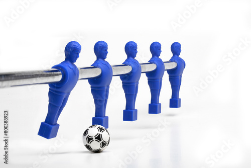 Foosball figures poised to kick the ball, (table soccer or table football)  on white background