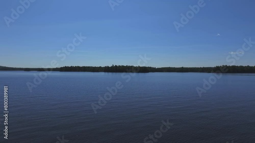 Drone capturing idyllic footage of Ambajejus Lake against clear blue sky in Maine photo