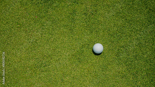 Golf ball is on a green lawn in a beautiful golf course with morning sunshine.