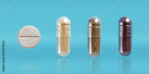 Biologically active additives. Tablet and capsules with gelatin shell on blue background with shadow and copy space
