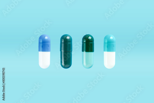 Various two-piece hard starch capsule on blue background with copy space. Biologically active additives. Health concept.