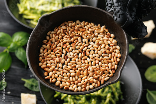 Roasted pine nuts on a cast iron pan ready to be sprinkled over pasta © grinchh