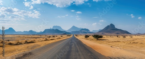 Long road in the desert, mountains in the background