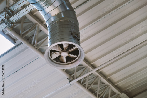 Ventilation pipe with fan mounted in ceiling of industrial room © bermuda cat