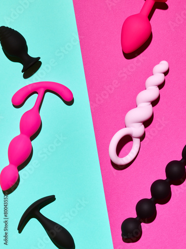 sex toys background. anal plugs and dildo over blue and pink backdrop