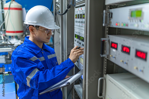Electrical engineer woman checking voltage at the Power Distribution Cabinet in the control room,preventive maintenance Yearly,Thailand Electrician working at company