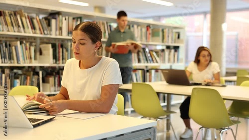 Smart female American student preparing for the exam in the school library photo