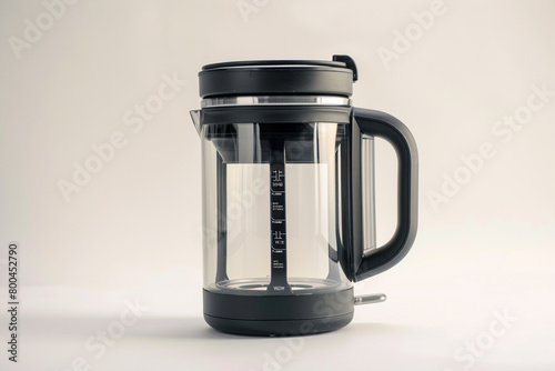 A compact travel-sized electric kettle with a collapsible silicone body and a dual voltage selector isolated on a solid white background. photo