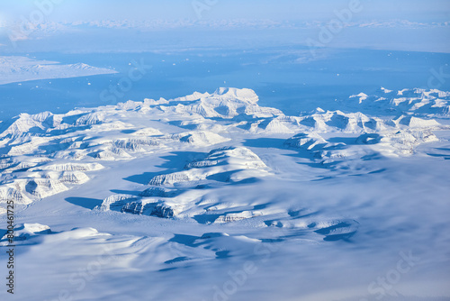 Aerial view of the Greenland with mountains and ocean bay during the flight from Europe to the United States.