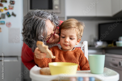 Grandma and grandchild in the kitchen at breakfast time