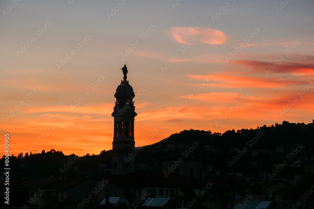 Scenic sunset view of tower of  church Chiesa di Sant Alessandro della Croce the town of Bergamo, Lombardy, Northern Italy, Europe. Romantic atmosphere in historical old town. Silhouette of buildings