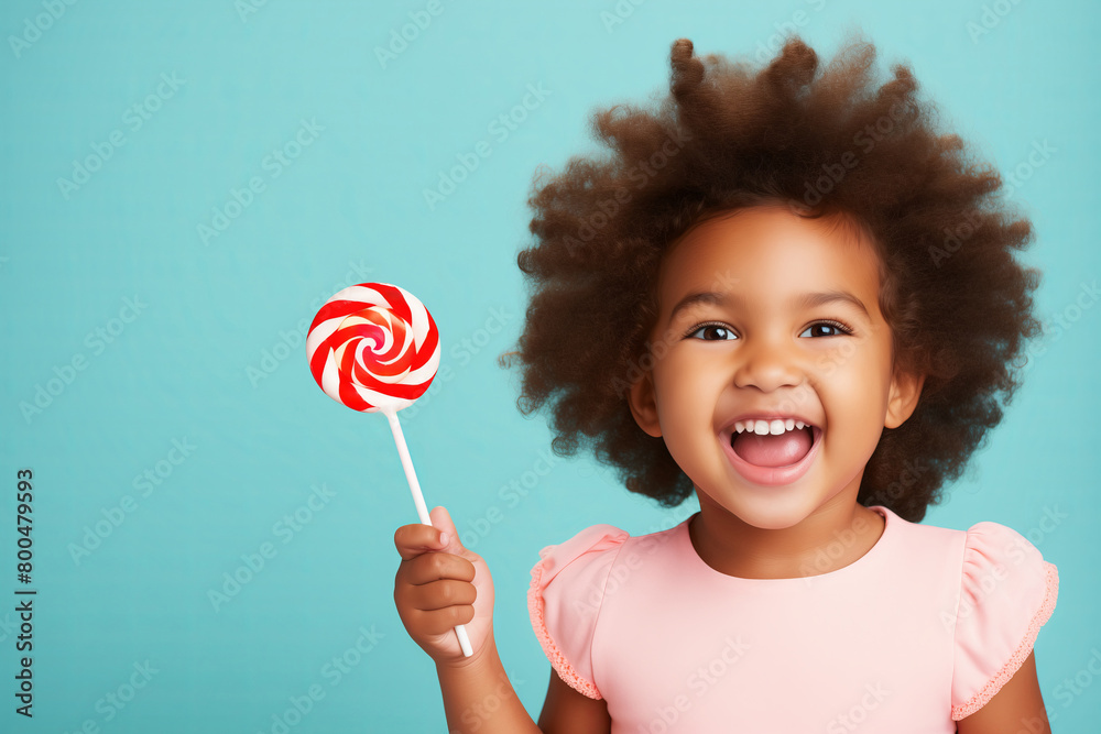 Happy Little Girl with afro Hairstyle Holding a candy Lollipop on Blue Background with copy space