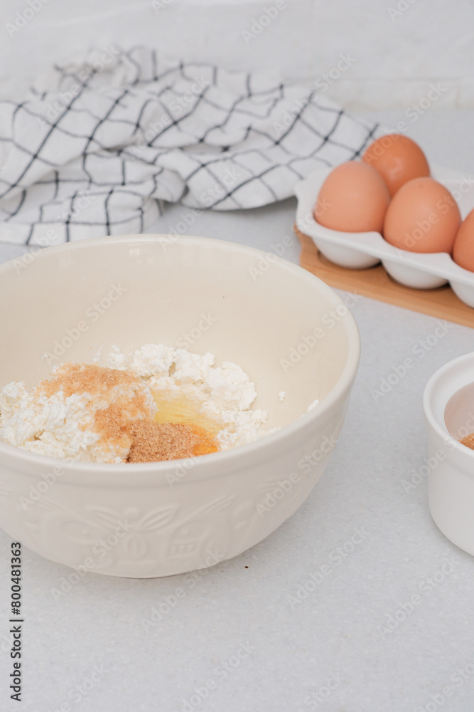 Home kitchen interior.Bowl with dough, eggs and bowl of sugar on kitchen table in modern kitchen. Home kitchen interior.Bowl with dough, eggs and bowl of sugar on kitchen table in modern kitchen.