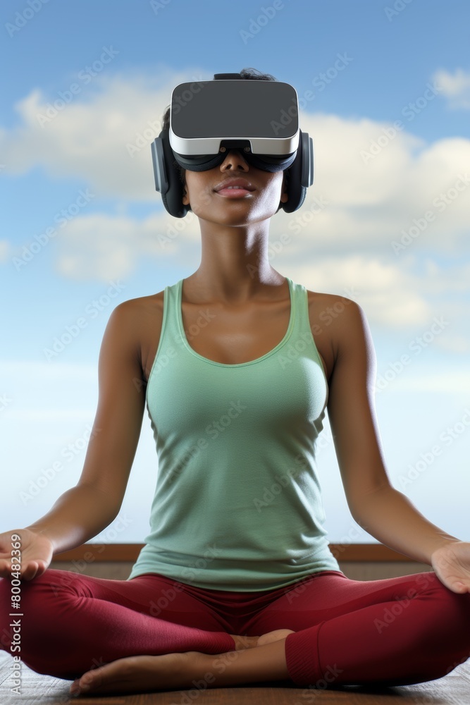 Fototapeta premium A young woman wearing a virtual reality headset is meditating in a yoga pose.