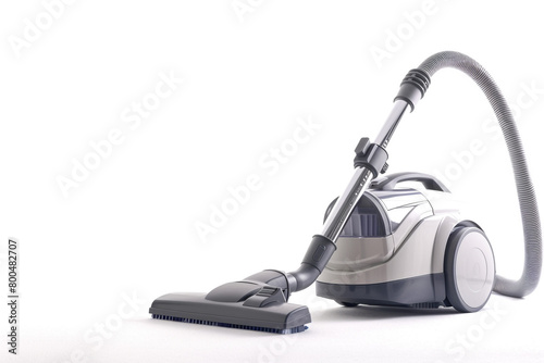 A bagged canister vacuum cleaner with a retractable cord and a variety of attachment tools isolated on a solid white background.
