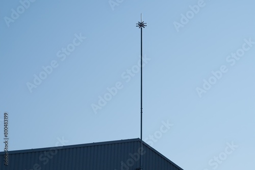 Lightning rod against blue sky. Active lightning protection of a building. Place for text.