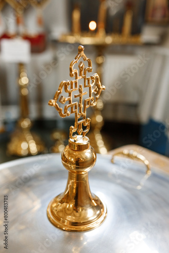 golden church cross on the lid of the baptismal font for a baby