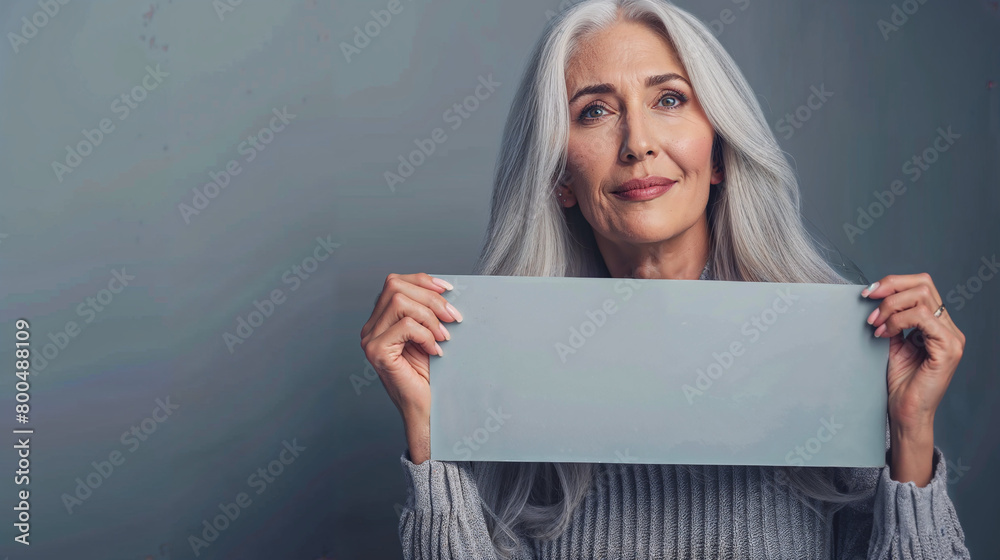 Naklejka premium A woman is holding a blank sign in her hands. Copy space