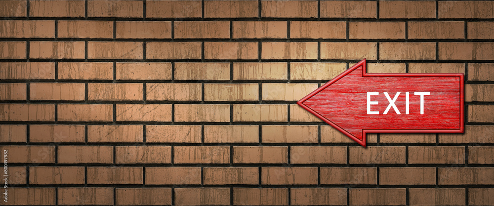 Red wooden shooter sign with the inscription EXIT hangs on a dark brick wall. Left arrow pointer Red wooden shooter sign with the inscription EXIT hangs on a dark brick wall. Left arrow pointer
