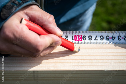Carpentry work, putting measurements on wood with a pencil
