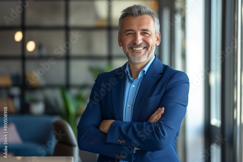 Happy middle aged business man ceo standing in office arms crossed. Smiling mature confident professional executive manager, proud lawyer, businessman leader wearing blue suit photo