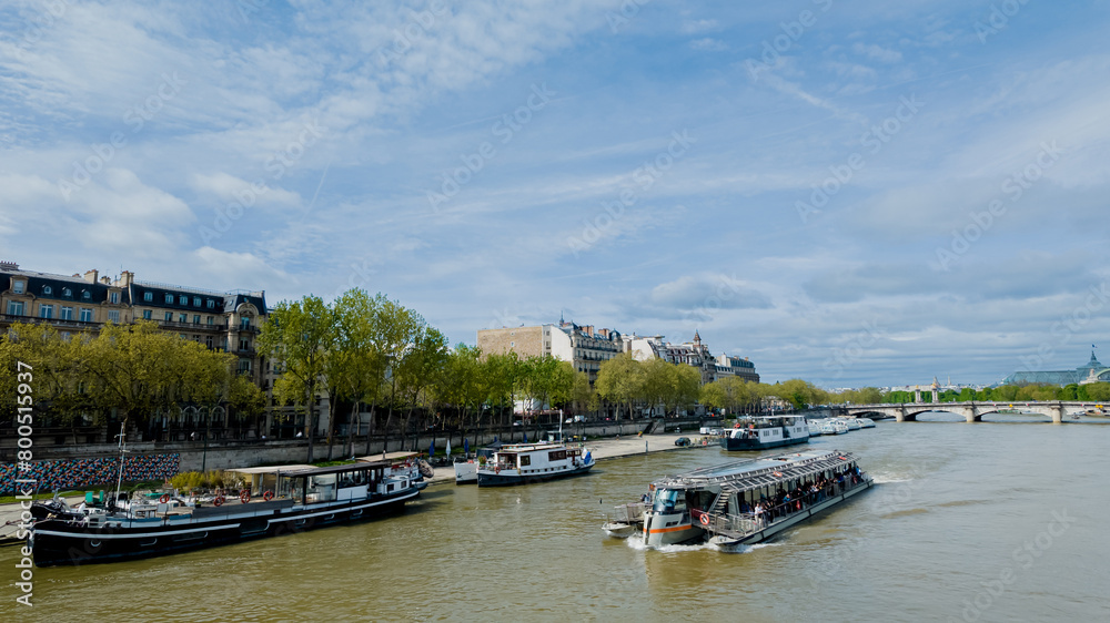 Scenic view of the Seine river with tour boats and Parisian architecture, ideal for travel, tourism, and French culture themes