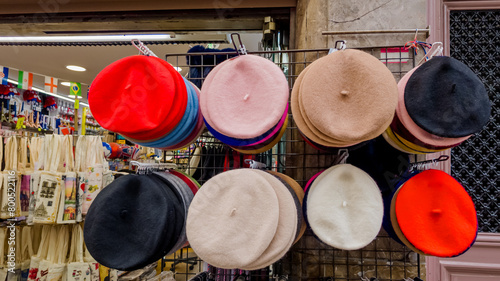 Photography Assorted colorful berets on display in a retail store, representing French fashi