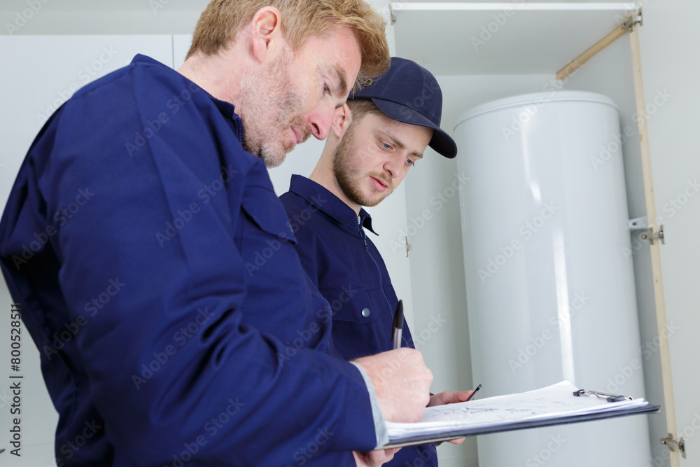 trainee plumber working on central heating boiler