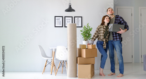 Happy young married couple are moving to new apartment, man and woman standing in a new house, banner