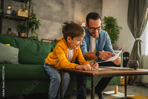 Father and son do homework together at home