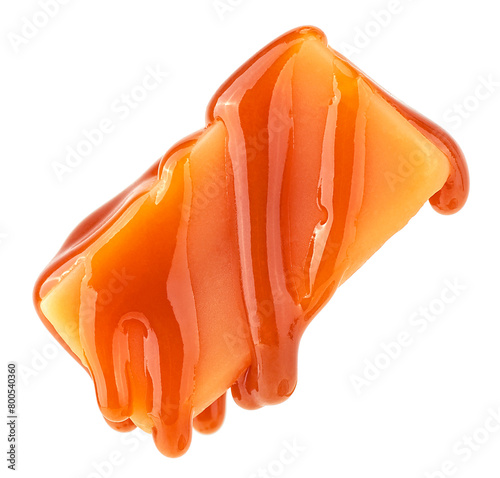 Caramel sauce flowing on caramel candy, isolated on a white background. Levitating caramel candy. © domnitsky