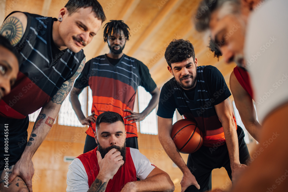 Fototapeta premium Portrait of a diverse basketball team having a team talk with their coach