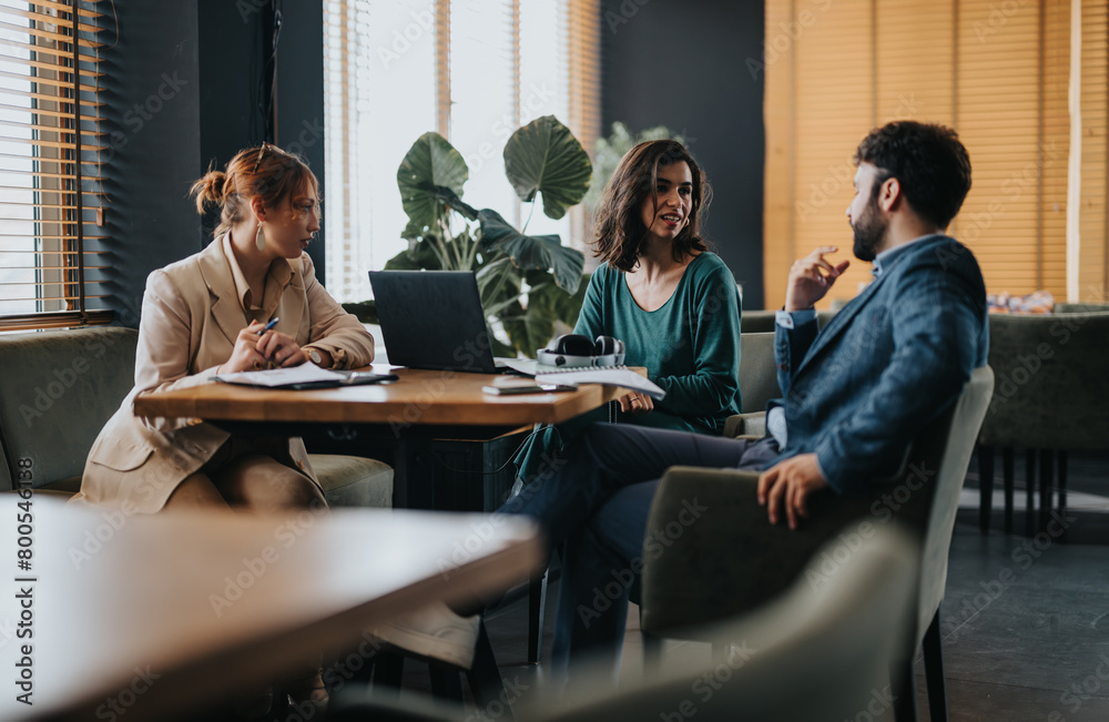 Three professionals collaborate and share ideas in a bright, contemporary office setting, showcasing teamwork and creativity. Three professionals collaborate and share ideas in a bright, contemporary office setting, showcasing teamwork and creativity.