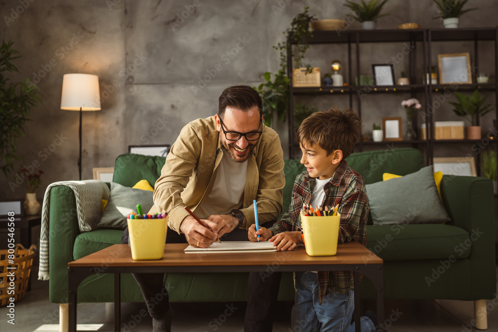Father and son draw and paint together at home leisure activity Father and son draw and paint together at home leisure activity