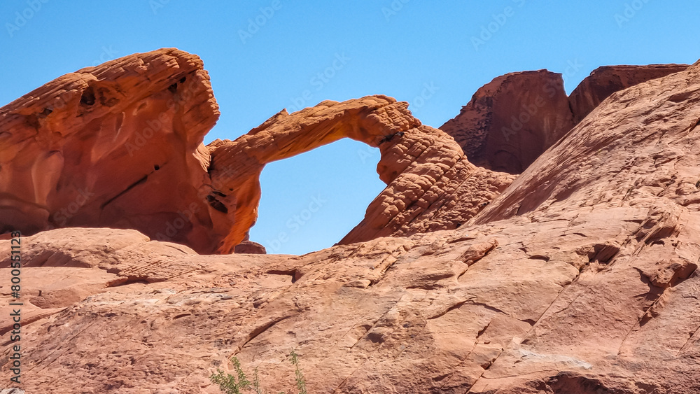 Scenic view of the iconic natural Arch Rock along Valley of Fire scenic loop,Valley of Fire State Park, Mojave desert, Nevada, USA. Landscape of Aztek red sandstone rock formations in barren terrain