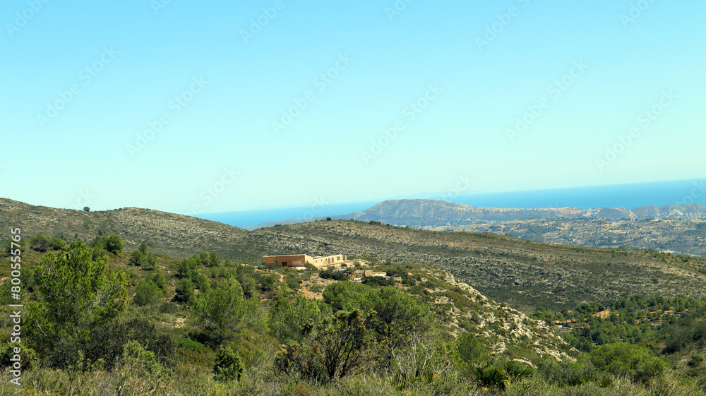 Beautiful mountain landscape, typical Spanish vegetation pine, juniper, palm trees, blue sky, sun, great place for relaxation and walks, Bernia mountains, Alicante province