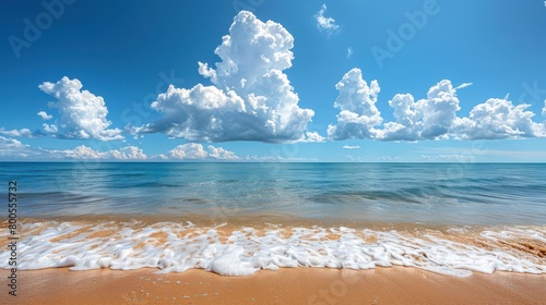 A picturesque seashore framed with gentle foam waves gently lapping the beach under a vast cloudy sky photo