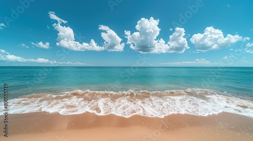 A pristine sandy beach stretches towards an inviting ocean, with a horizon crowned by a dramatic cloud formation photo