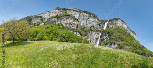 Large panorama of the Seerenbach Falls in spring with a green meadow and a blue sky photo