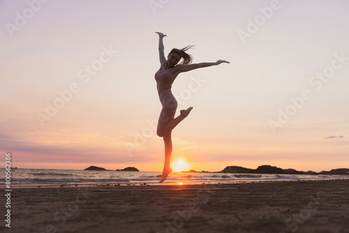 Silhouette workout woman stretching arms and legs exercising during sunset at the beach  Yoga concept