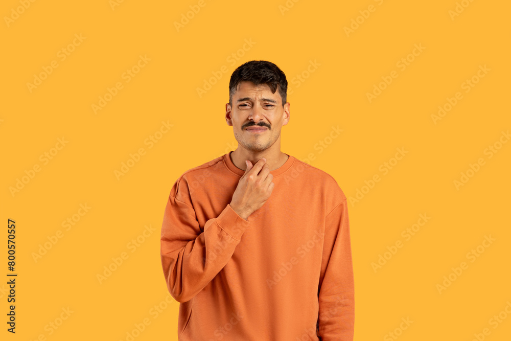 Pensive Young Man With Mustache Touching His Neck Pensive Young Man With Mustache Touching His Neck