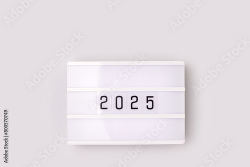 White lightbox with 2025 numbers on a gray background with copy space. New Year composition.