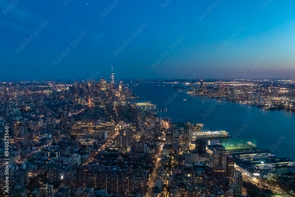 Captivating aerial view of New York's skyline and Hudson River right after the sunset seen from The Edge. The city is lit up by neon lights. Endless rows of buildings. Bustling city. Endless horizon