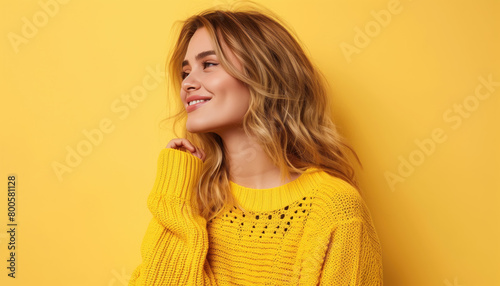 Happy young blonde-haired woman looking away against a bright yellow background © WD Stockphotos