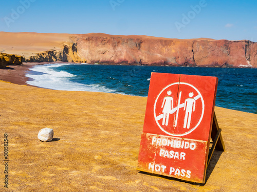 Impressive view of Red Beach in Paracas National Reserve with No Trespassing signboard on foreground, Ica region, Peru