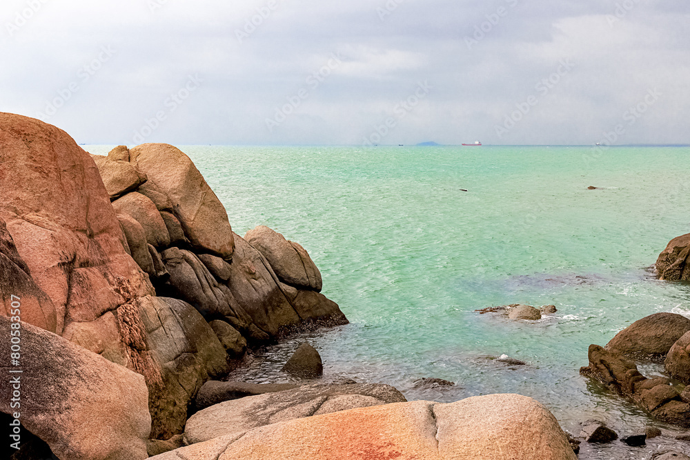 View of large rocks along the shore of the South China Sea. Sky Grottoes Park, Sanya, China View of large rocks along the shore of the South China Sea. Sky Grottoes Park, Sanya, China