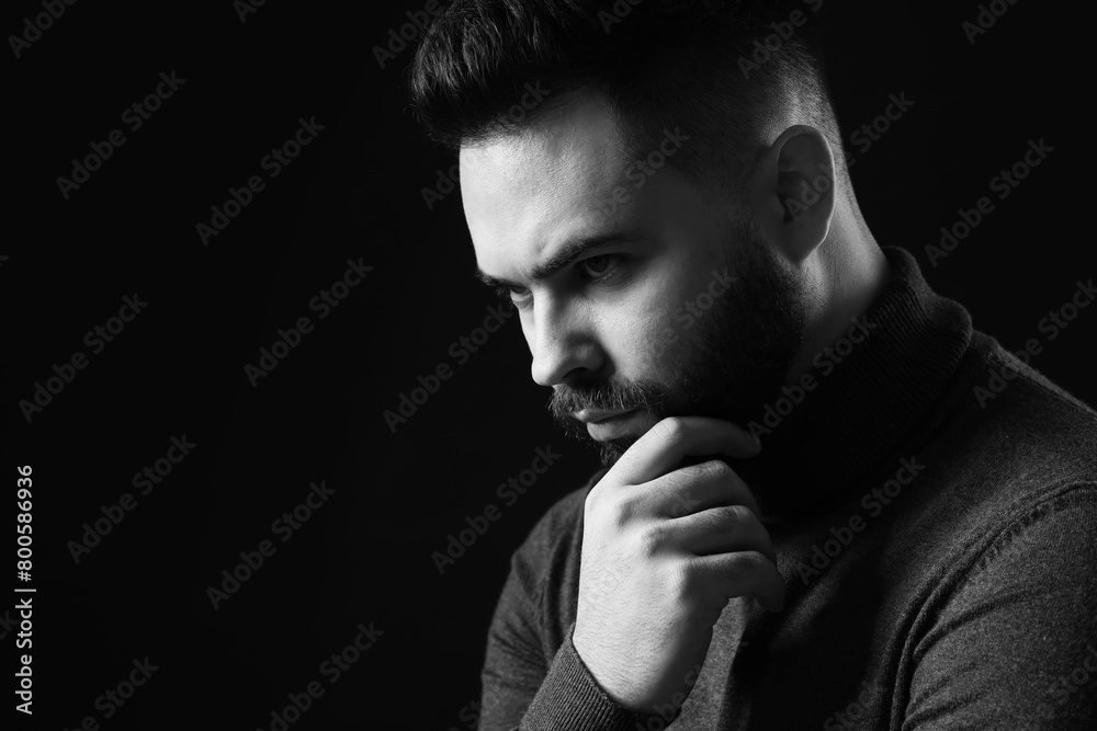 Portrait of handsome bearded man on dark background, space for text. Black and white effect