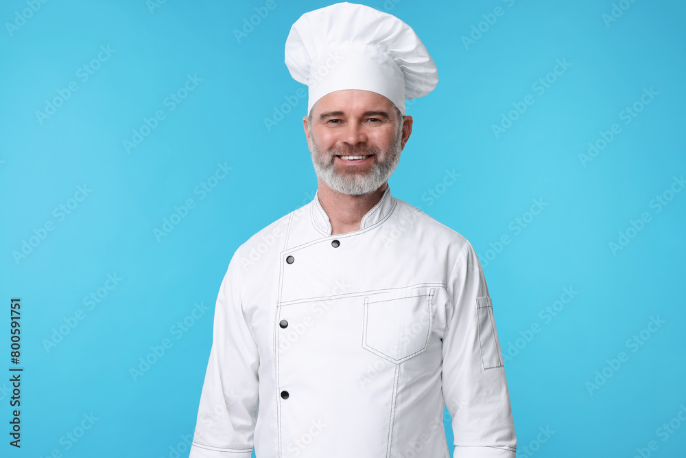 Happy chef in uniform on light blue background Happy chef in uniform on light blue background